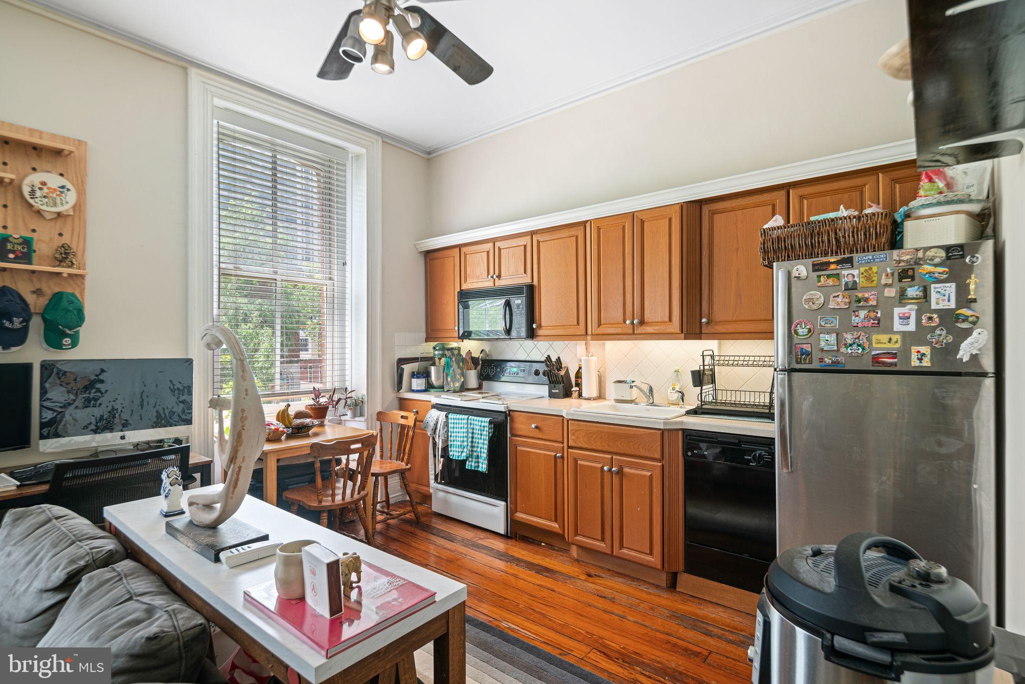 1935 Spring Garden Street Philadelphia, PA 19130 - Photo 34 of 49 a kitchen with stainless steel appliances granite countertop a stove a sink dishwasher and a dining table with wooden floor