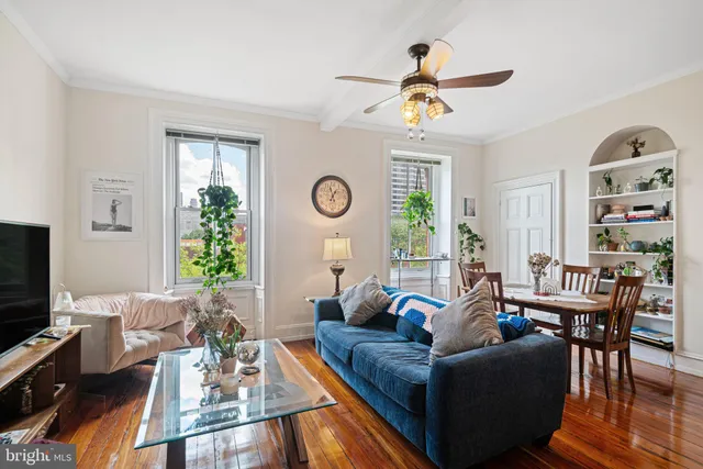 a living room with furniture kitchen view and a large window