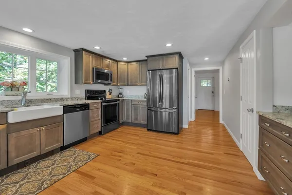 a large kitchen with stainless steel appliances granite countertop a stove refrigerator and a sink