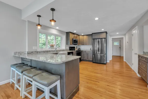 a kitchen with stainless steel appliances granite countertop counter space a sink and a refrigerator