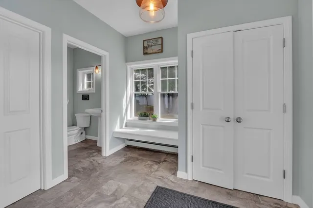 a view of a hallway with bathroom and front door