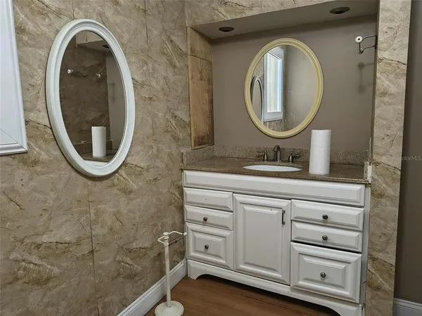 a bathroom with a sink a mirror a vanity and a window
