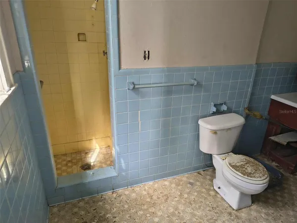 a bathroom with a toilet and a shower