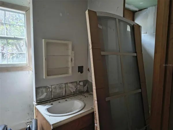 a bathroom with a sink a mirror and shower