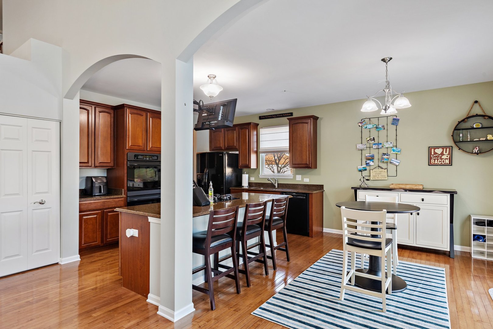 5617 Red Oak Drive Hoffman Estates, IL 60192 - Photo 12 of 30 a kitchen with stainless steel appliances wooden floor dining table and chairs