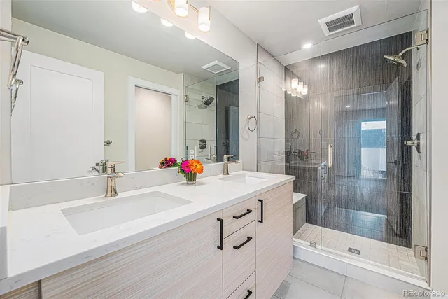 a bathroom with a sink shower and a mirror