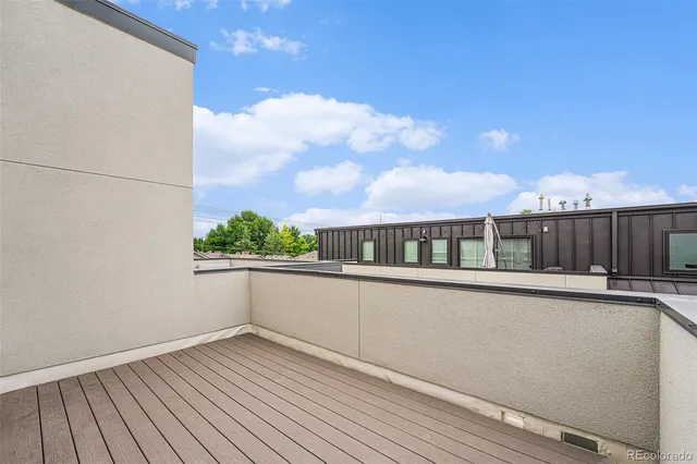 a view of a balcony with wooden floor and a floor to ceiling window