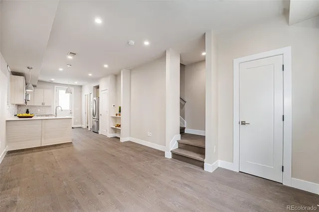 a view of a kitchen with refrigerator and white cabinets