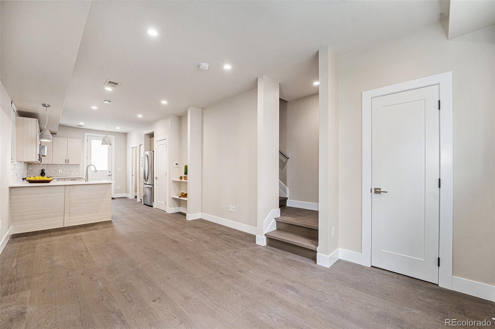 409 Harrison Street, Unit 2 Denver, CO 80206 - Photo 2 of 19 a view of a kitchen with refrigerator and white cabinets