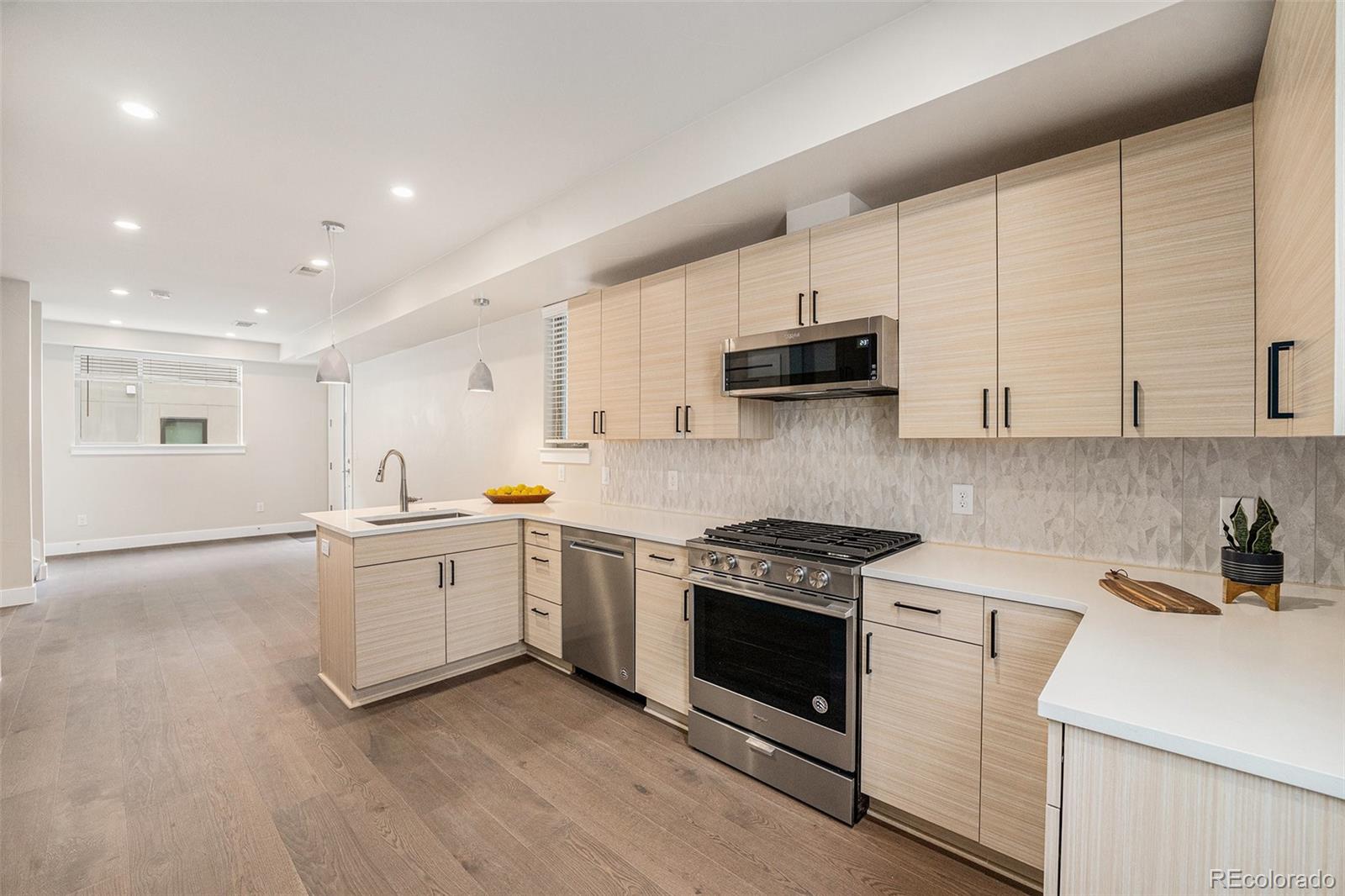 409 Harrison Street, Unit 2 Denver, CO 80206 - Photo 3 of 19 a kitchen with a stove a sink and a refrigerator