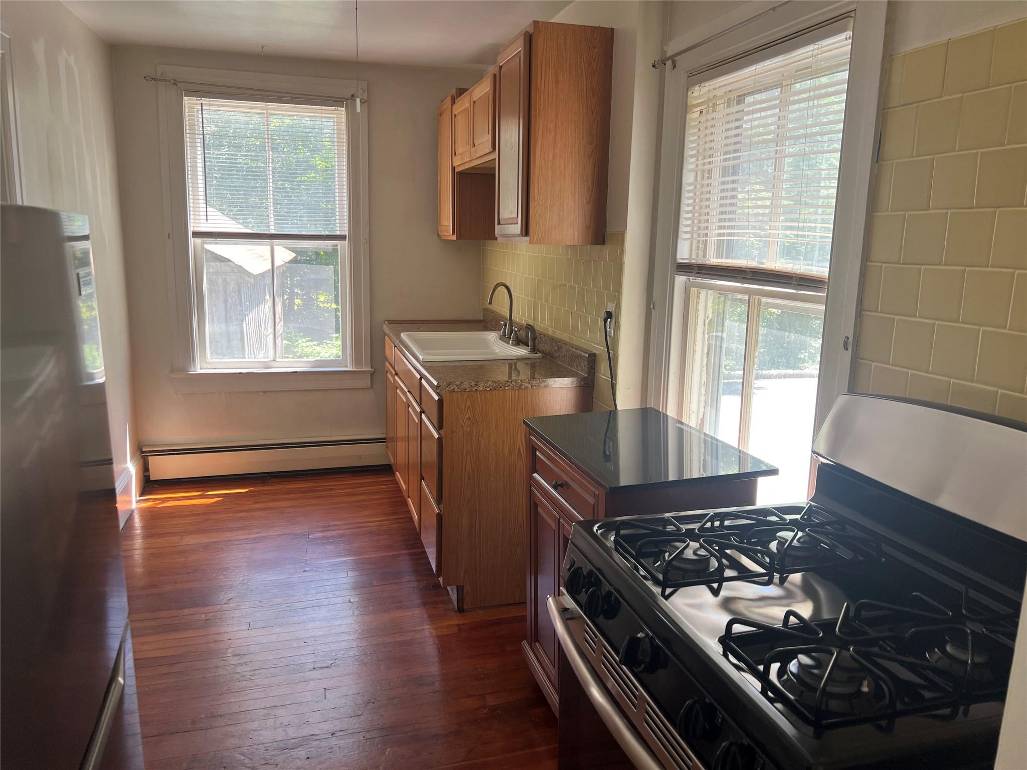 20 Continental Road Cornwall, NY 12518 - Photo 3 of 19 an open kitchen with granite countertop a stove and wooden floor