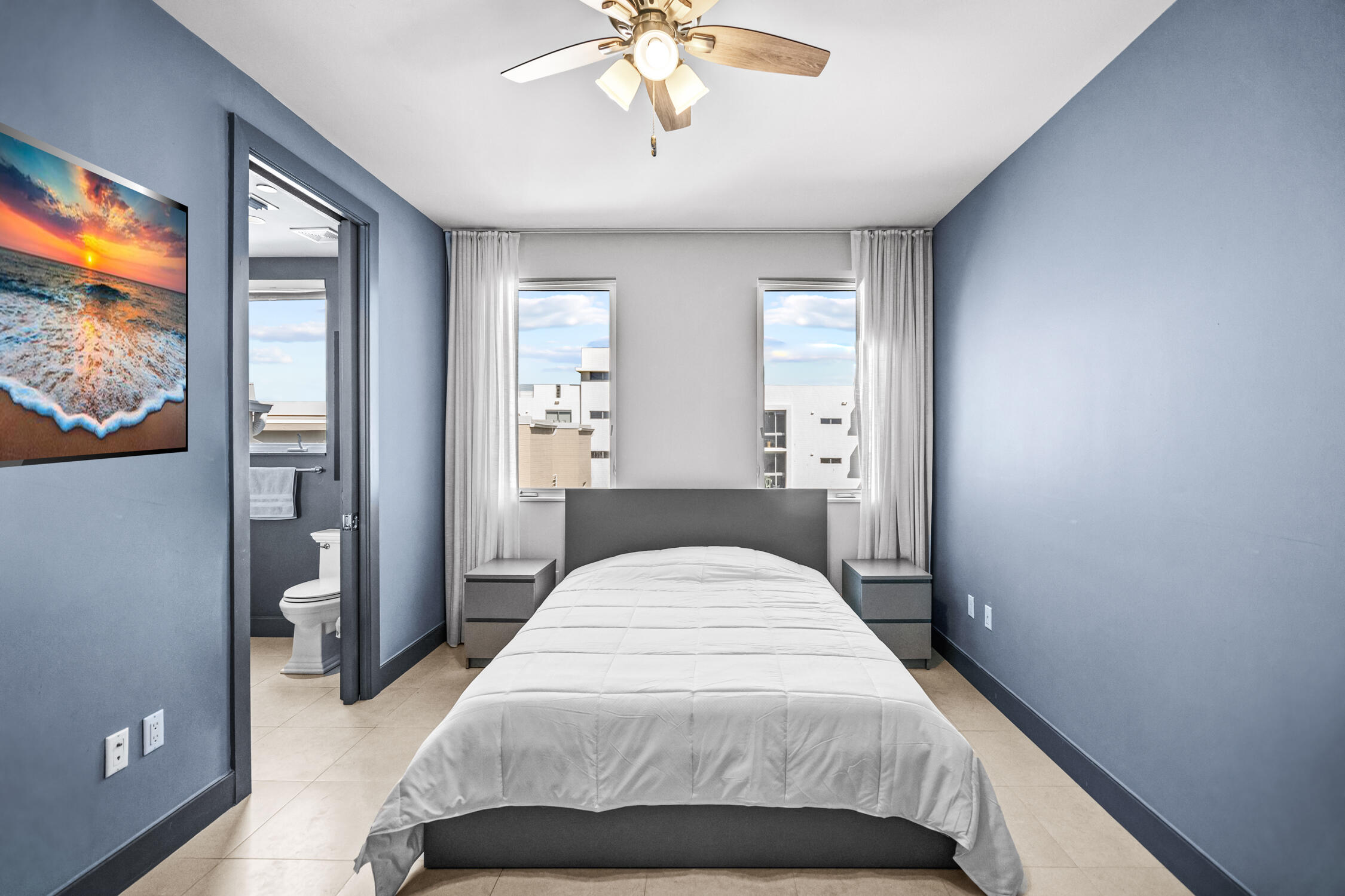 111 Southeast 2nd Street, Unit 401 Delray Beach, FL 33444 - Photo 6 of 38 a bedroom with a large bed and a chandelier