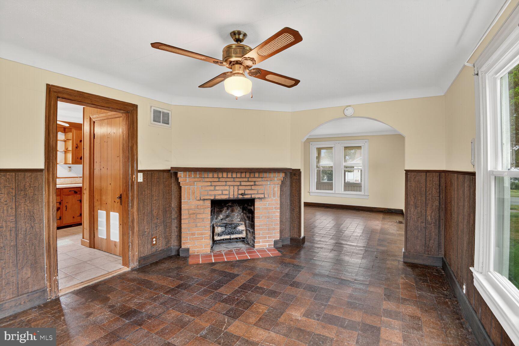 10437 Main Street Claiborne, MD 21624 - Photo 17 of 44 a view of a livingroom with a fireplace a ceiling fan and front door
