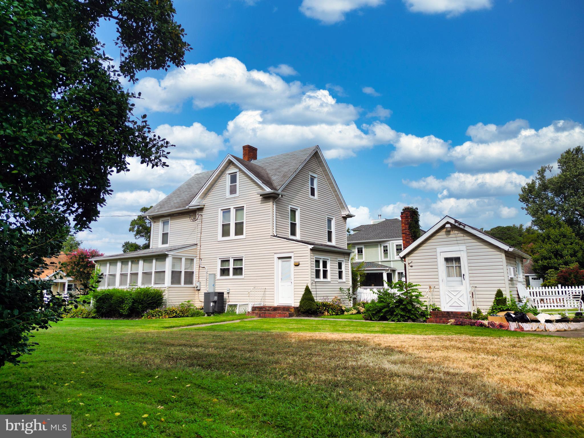 10437 Main Street Claiborne, MD 21624 - Photo 8 of 44 a view of a white house with a big yard and large trees