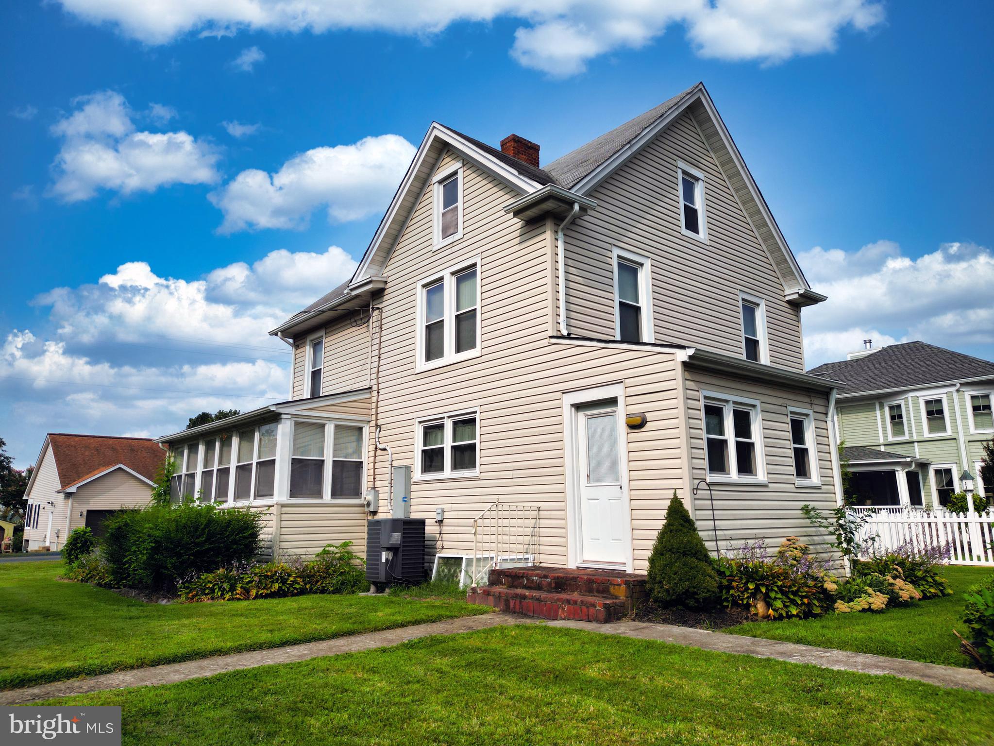 10437 Main Street Claiborne, MD 21624 - Photo 9 of 44 a front view of a house with a garden and plants