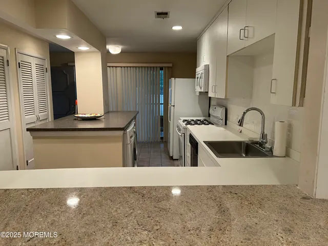 a kitchen with stainless steel appliances granite countertop a sink a stove and a refrigerator