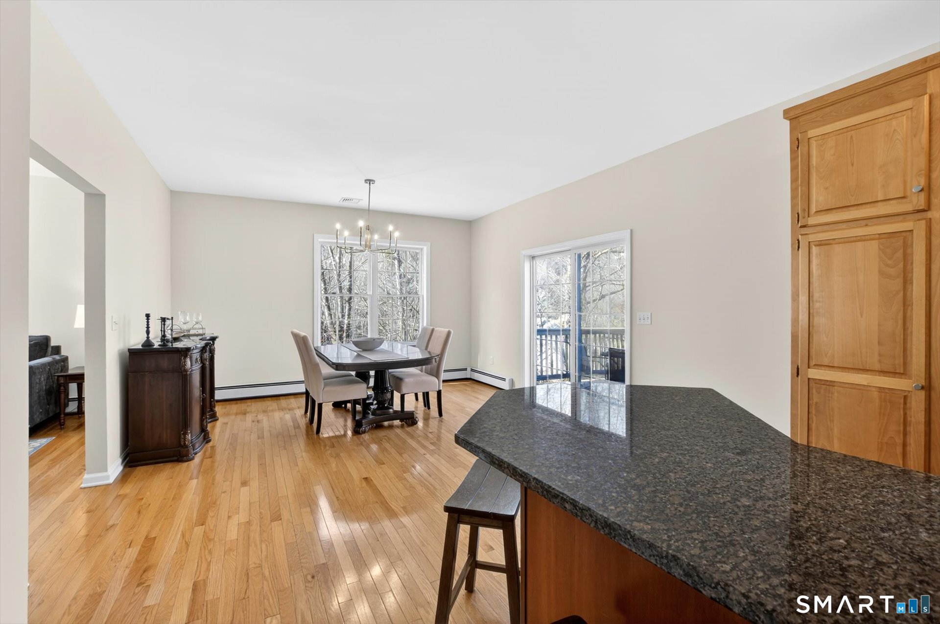 16 A Claire Hill Road Burlington, CT 06013 - Photo 12 of 37 a dining room with wooden floor a chandelier a wooden table and chairs