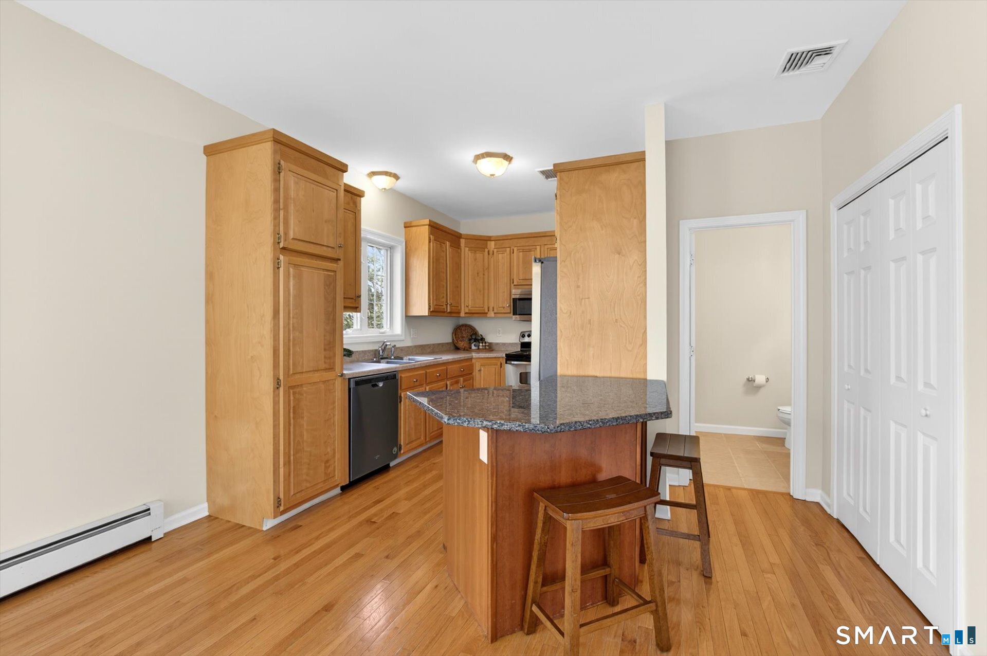 16 A Claire Hill Road Burlington, CT 06013 - Photo 9 of 37 a kitchen with kitchen island wooden cabinets and refrigerator