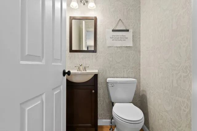 a bathroom with a toilet a sink and mirror