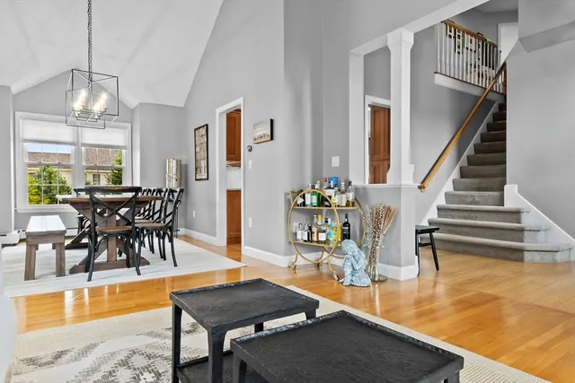 a view of a dining room with furniture a chandelier and wooden floor