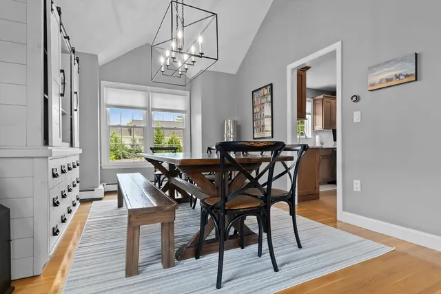a view of a dining room with furniture a chandelier and wooden floor