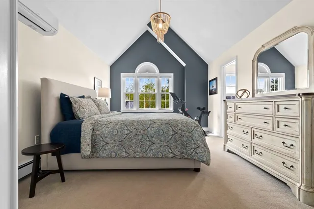 a bedroom with a bed a dresser and window