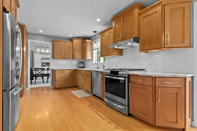 a kitchen with stainless steel appliances granite countertop a stove a sink dishwasher and a refrigerator