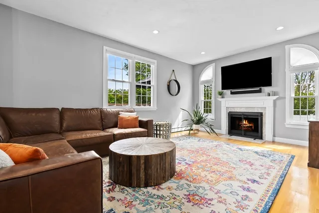 a living room with furniture a flat screen tv and a fireplace