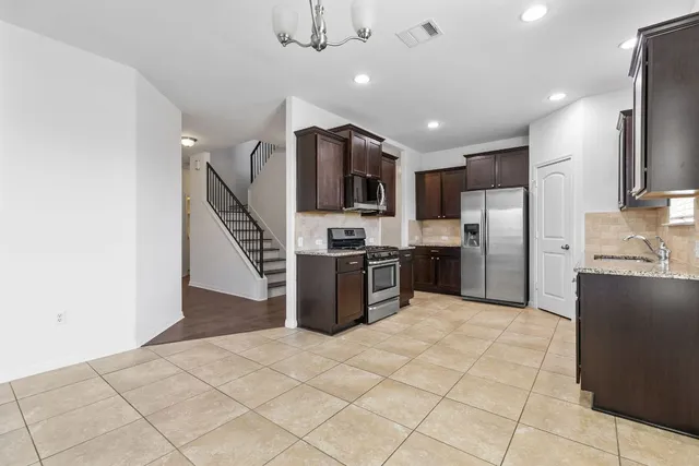 a kitchen with stainless steel appliances granite countertop a refrigerator and a sink