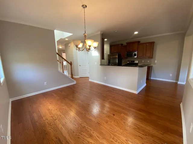 a view of a room with wooden floor and a chandelier