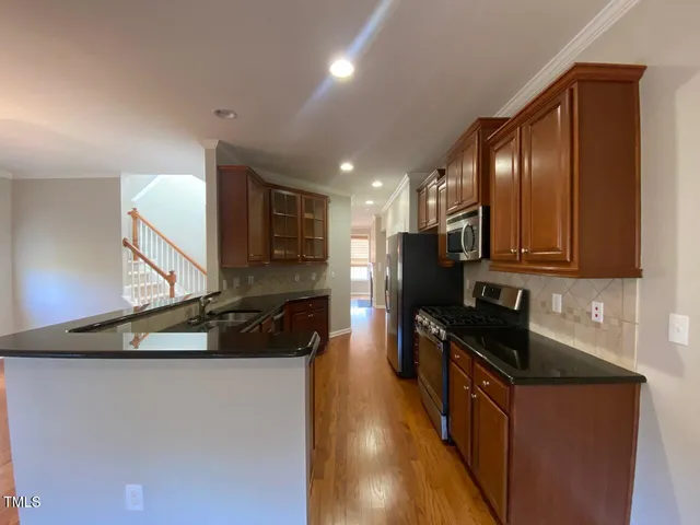 a kitchen with stainless steel appliances granite countertop a sink and a stove top oven