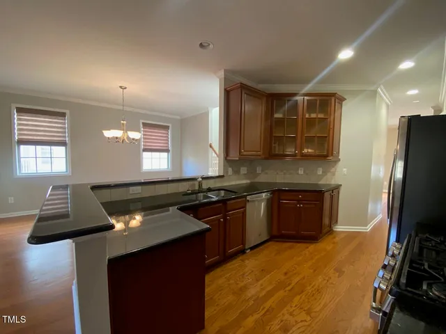 a kitchen with kitchen island granite countertop a stove refrigerator and microwave