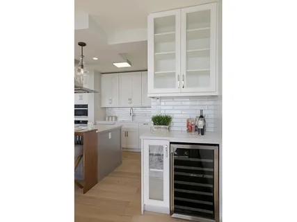 a kitchen with white cabinets and appliances