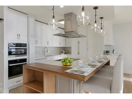 a kitchen with kitchen island granite countertop a sink cabinets and stainless steel appliances