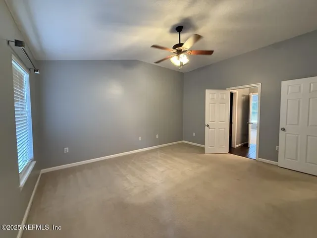 an empty room with a window and a fan