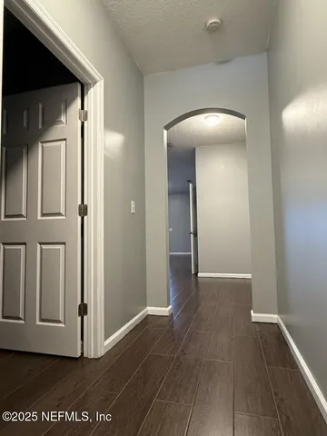 a view of a hallway with wooden floor