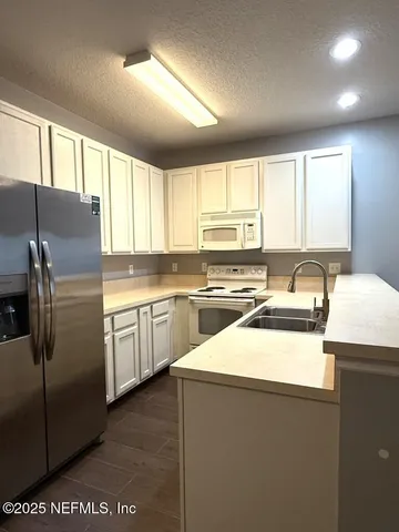 a kitchen with stainless steel appliances a refrigerator sink and cabinets