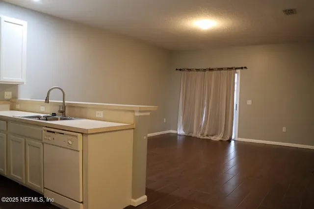 a kitchen with a sink and wooden floor