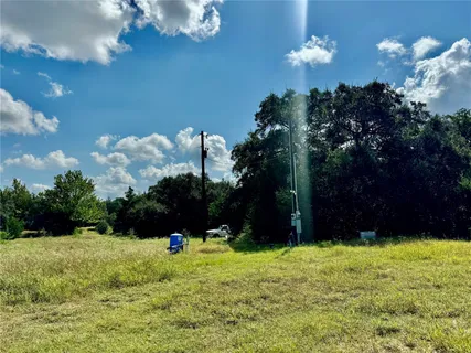 a view of swimming pool with outdoor seating and trees in the background