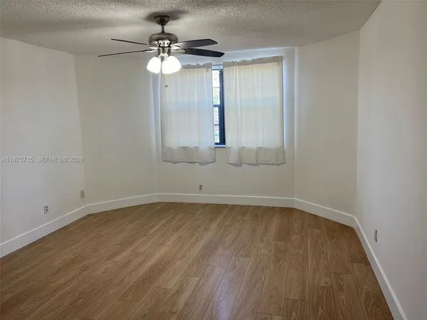 a view of a small space with wooden floor and a window