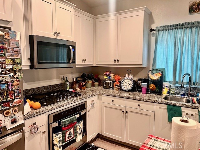 34434 Solstice Street Winchester, CA 92596 - Photo 8 of 11 a kitchen with stainless steel appliances granite countertop a stove a sink dishwasher and cabinets with wooden floor