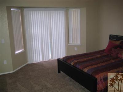 45655 Rogue River Road Indio, CA 92201 - Photo 6 of 12 a bed sitting in a bedroom next to a window