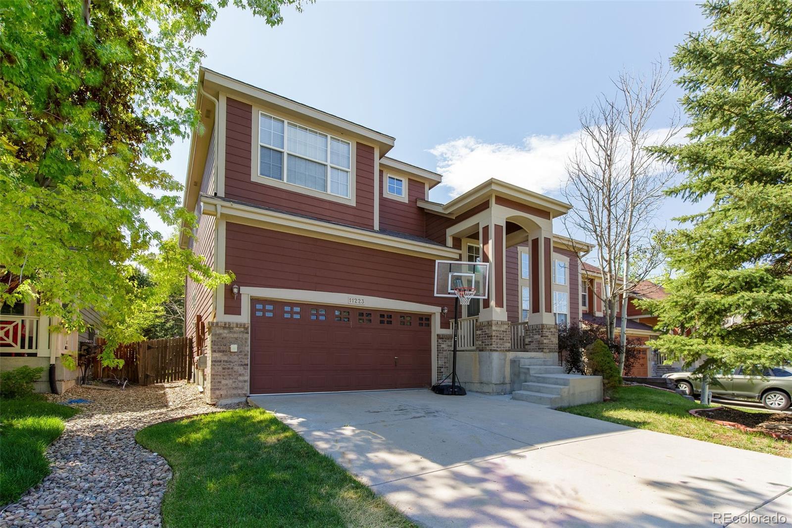 11223 Plover Circle Parker, CO 80134 - Photo 1 of 35 a view of a brick house with a yard and large tree