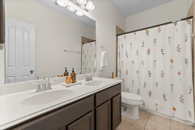 a bathroom with a double vanity sink toilet and shower