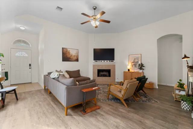 a living room with furniture a fireplace and a flat screen tv