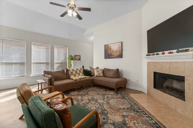 a living room with furniture a flat screen tv and a fireplace