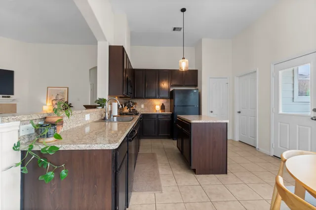 a kitchen with stainless steel appliances granite countertop a sink a stove and a wooden floors