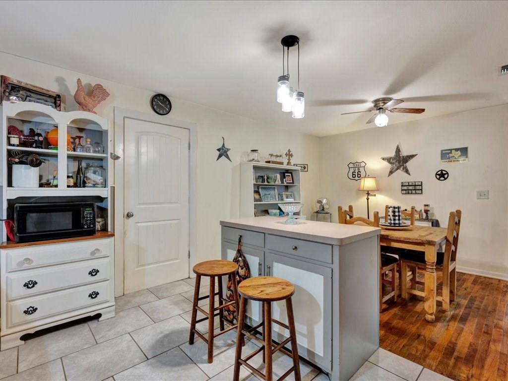 635 Oscar Berry Road Lufkin, TX 75904 - Photo 13 of 36 a kitchen with stainless steel appliances kitchen island granite countertop a table chairs in it and a wooden floors