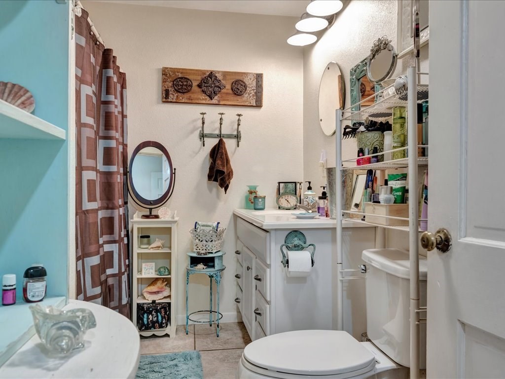635 Oscar Berry Road Lufkin, TX 75904 - Photo 19 of 36 a bathroom with a toilet a sink and a mirror