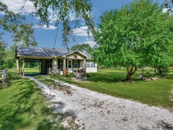 a front view of a house with yard and green space